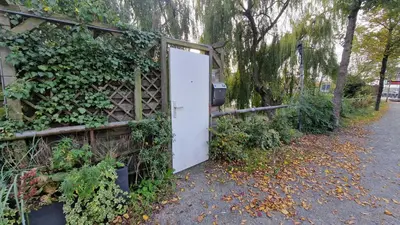 a white door in the side of a fence at Cornelia Below Deck in Amsterdam