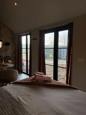 a bedroom with a bed and a large window at B&B Landslake II in Landsmeer