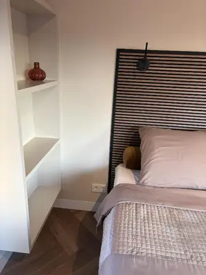 a bedroom with a bed with a black and white headboard at B&B Landslake II in Landsmeer