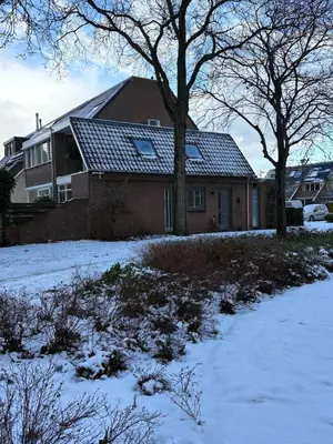 a house with snow on the ground in front of it at Vakantiehuis Neptunus voor het hele gezin eventueel met baby in Katwijk aan Zee