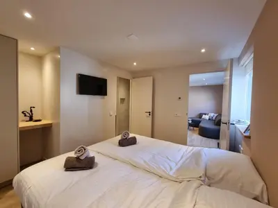 a bedroom with a large white bed with two towels on it at LÖYLY Egmond in Egmond aan Zee