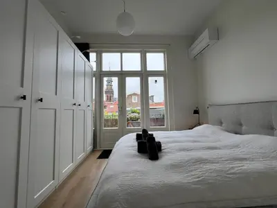 a bedroom with a large bed with a large window at Modern & Luxurious stay Haarlem in Haarlem