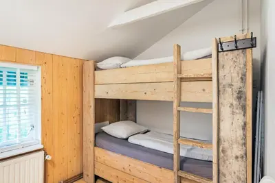 a bunk bed room with two bunk beds and a ladder at farmhouse in Wijdewormer