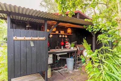 an outdoor kitchen with a shed with a gate at farmhouse in Wijdewormer