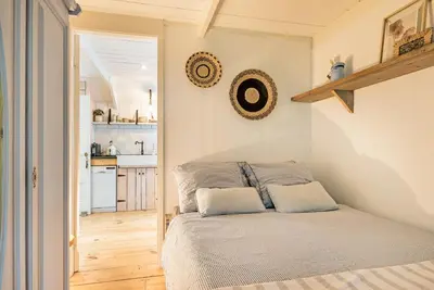 a small bedroom with a bed and a kitchen at farmhouse in Wijdewormer