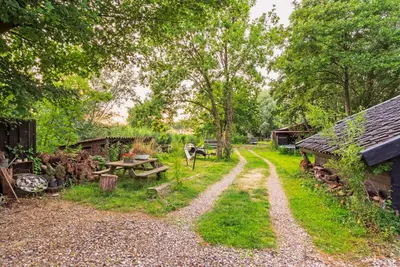 a path leading into a garden with a picnic table and buildings at farmhouse in Wijdewormer
