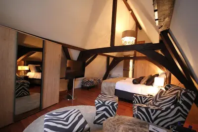 a room with two beds and chairs in a room at Boutique Hotel Steenhof Suites - Adults Only in Leiden