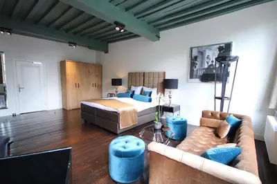 a bedroom with a bed and a couch at Boutique Hotel Steenhof Suites - Adults Only in Leiden