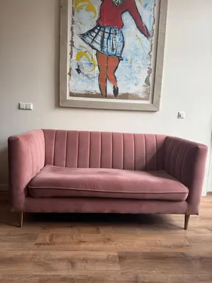 a pink couch in a living room with a painting at studio at the Rijksmuseum in Amsterdam
