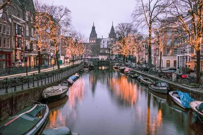 a river with boats in a city with buildings at studio at the Rijksmuseum in Amsterdam