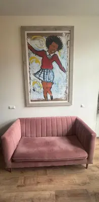 a pink couch in a room with a painting on the wall at studio at the Rijksmuseum in Amsterdam