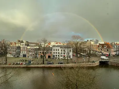 a rainbow over a city with a river and buildings at studio at the Rijksmuseum in Amsterdam