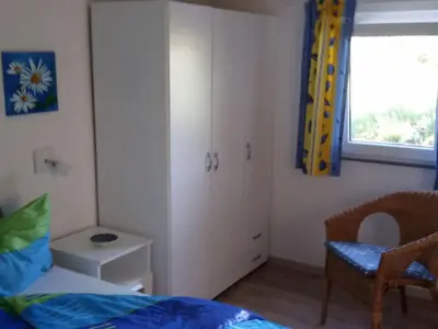 a bedroom with a bed and a chair and a window at Apartment Haus Jule by Interhome in Wervershoof