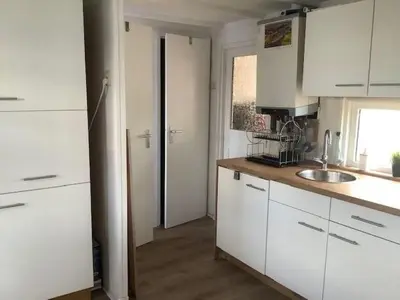 a kitchen with white cabinets and a sink at Apartment Chalet Meise by Interhome in Wervershoof