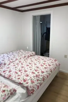 a bedroom with a bed with a flowered blanket on it at Apartment Chalet Meise by Interhome in Wervershoof