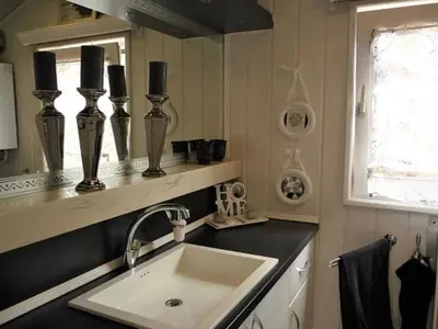 a kitchen with a sink and a mirror at Holiday Home De Graaf by Interhome in Wervershoof