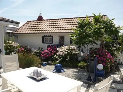 a white table and chairs in front of a house at Holiday Home De Graaf by Interhome in Wervershoof