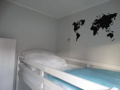 a room with a bed with a map of the world on the wall at Holiday Home Schönes Ferienhaus in Wervershoof mit Garten- Grill und Terrasse by Interhome in Wervershoof