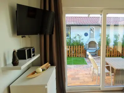 a living room with a sliding glass door to a patio at Holiday Home Schönes Ferienhaus in Wervershoof mit Garten- Grill und Terrasse by Interhome in Wervershoof