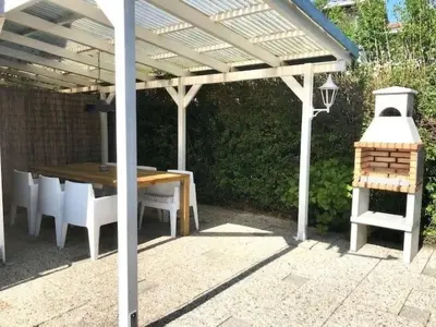a wooden pergola with a table and a grill at Holiday Home in Wervershoof mit Terrasse und Garten by Interhome in Wervershoof