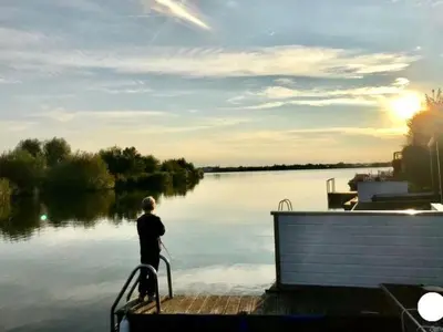 a man standing on a dock near a body of water at Holiday Home in Wervershoof mit Terrasse und Garten by Interhome in Wervershoof