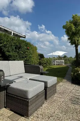 a patio with a couch and a table and a bench at Holiday Home in Wervershoof mit Terrasse und Garten by Interhome in Wervershoof
