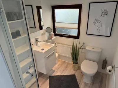 a bathroom with a toilet and a sink and a window at Holiday Home in Wervershoof mit Terrasse und Garten by Interhome in Wervershoof
