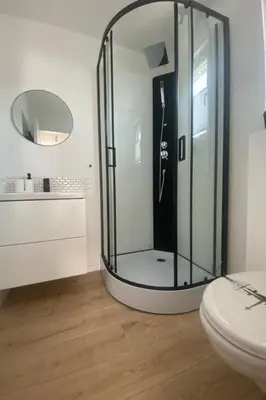 a glass shower in a bathroom with a toilet at Holiday Home Sonnenschein by Interhome in Wervershoof