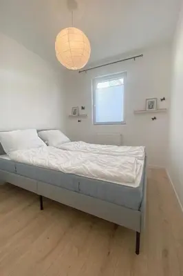 a bed in a white room with a window at Holiday Home Sonnenschein by Interhome in Wervershoof