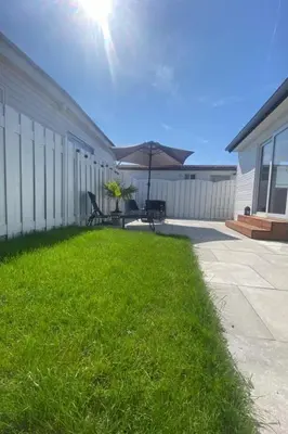 a patio with a table and an umbrella in the grass at Holiday Home Sonnenschein by Interhome in Wervershoof