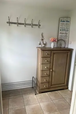 a room with a dresser and a shelf on the wall at Holiday Home Charmantes Ferienhaus Hilda mit Terrasse by Interhome in Wervershoof