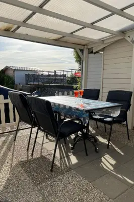 a table with chairs and drinks on a patio at Holiday Home Charmantes Ferienhaus Hilda mit Terrasse by Interhome in Wervershoof