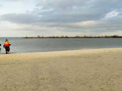 a person walking on a beach near the water at Holiday Home Charmantes Ferienhaus Hilda mit Terrasse by Interhome in Wervershoof
