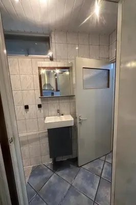 a bathroom with a sink and a mirror and a door at Holiday Home by Interhome in Wervershoof