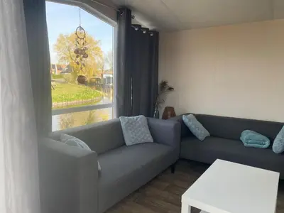 a living room with a couch and a large window at Holiday Home Haus Jeff by Interhome in Wervershoof