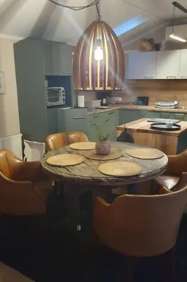 a kitchen with a table and some chairs and a kitchen with a kitchenventory at Holiday Home Chalet op Zee by Interhome in Wervershoof