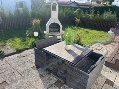 a table and chairs with a grill in a backyard at Apartment Haus Moony by Interhome in Wervershoof