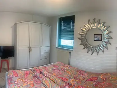 a bedroom with a bed and a mirror on the wall at Holiday Home in Dirkshorn by Interhome in Dirkshorn