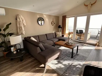 a living room with a couch and a table at Holiday Home Exklusive Ferienhäuser Markermeer by Interhome in Bovenkarspel