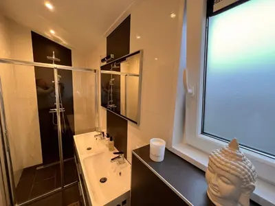 a bathroom with a sink and a toilet and a window at Holiday Home Exklusive Ferienhäuser Markermeer by Interhome in Bovenkarspel