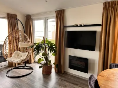 a living room with a fireplace with a flat screen tv at Holiday Home Exklusive Ferienhäuser Markermeer by Interhome in Bovenkarspel