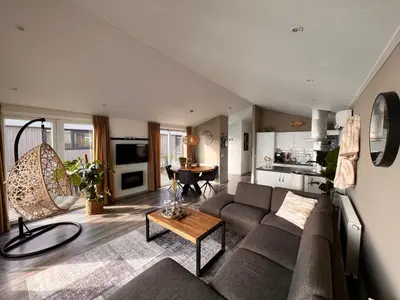 a living room with a couch and a table at Holiday Home Exklusive Ferienhäuser Markermeer by Interhome in Bovenkarspel