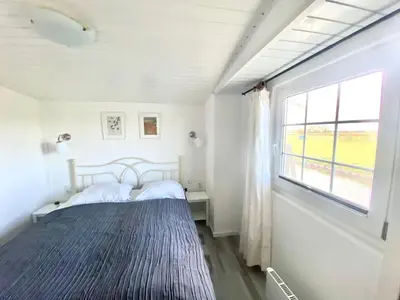a bedroom with a bed and a window at Holiday Home Isabella by Interhome in Wervershoof