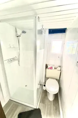 a white bathroom with a toilet and a shower at Holiday Home Isabella by Interhome in Wervershoof
