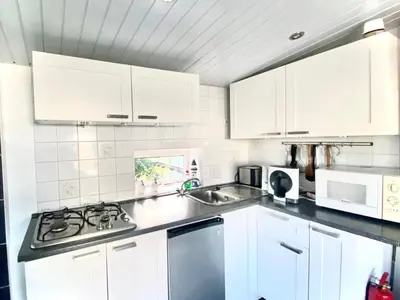 a white kitchen with white cabinets and a sink at Holiday Home Isabella by Interhome in Wervershoof