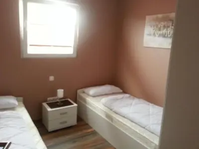 a small bedroom with two beds and a window at Holiday Home Auszeit direkt am Wasser by Interhome in Wervershoof