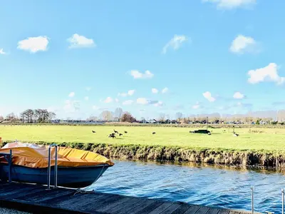 a boat sitting on a dock next to a river at Holiday Home Balu by Interhome in Wervershoof