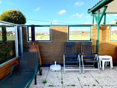 two chairs sitting on the back porch of a house at Holiday Home Balu by Interhome in Wervershoof