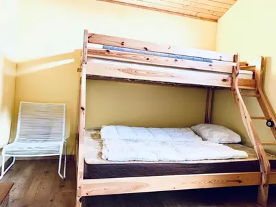 a bunk bed in a room with a chair at Holiday Home Balu by Interhome in Wervershoof