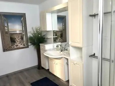 a white bathroom with a sink and a mirror at Holiday Home Haus DE BLAUWE REIGER by Interhome in Wervershoof